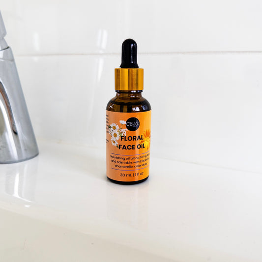 Bottle of floral face oil with dropper on a bathroom counter