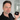 Man holding a black jar with 'QBlack' branding in an indoor setting.
