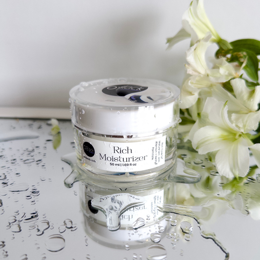 Jar of Rich Moisturizer with flowers on a reflective surface