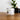 Jar of rich moisturizer on a wooden surface with a plant in the background
