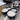 Three containers of white cream on a metallic surface with a metal bowl in the background.