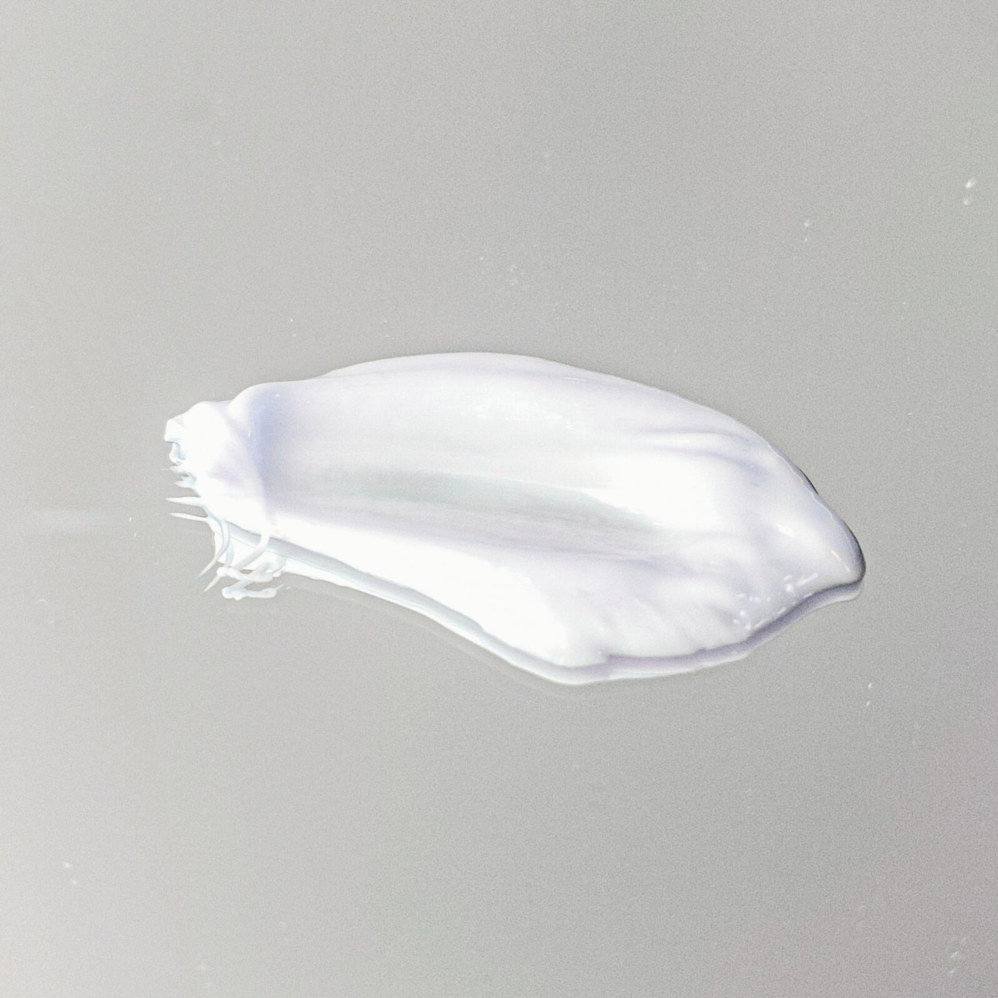 White cream smear on a gray background