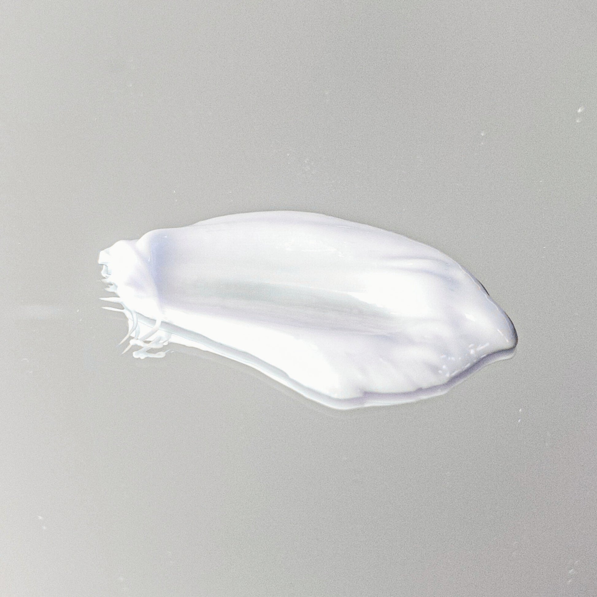 White cream smear on a gray background