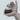 Hand holding a jar of PrimeUltra Daily Cream against a light blue background
