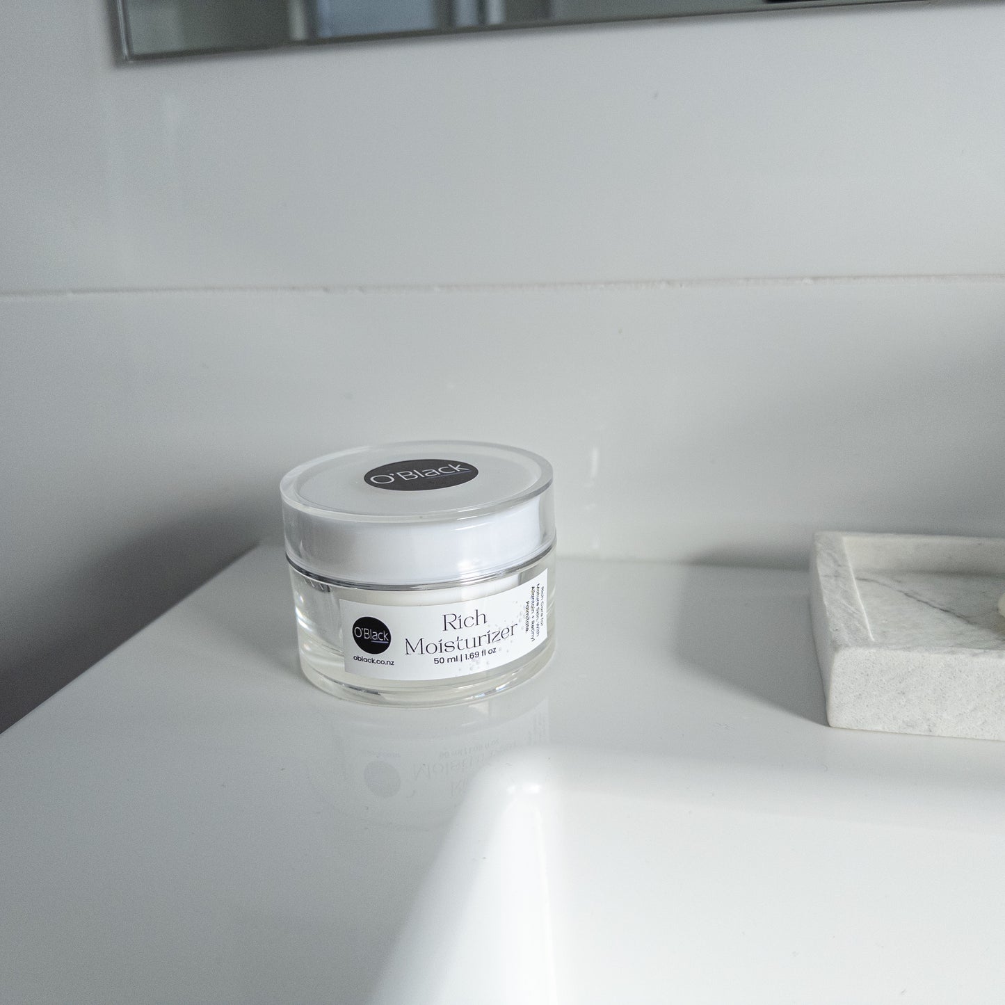 Jar of Rich Moisturizer on a white surface with a neutral background