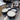 Three containers of white cream on a metallic surface with a metal bowl in the background.